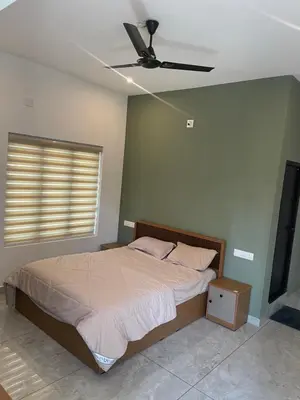 a bedroom with a bed and a ceiling fan at Vijay Home Stays in Batheri