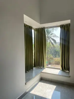 a room with a large window with green curtains at Vijaya Home Stay in Batheri