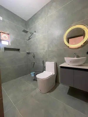 a bathroom with a toilet and a sink and a mirror at Vijaya Home Stay in Batheri