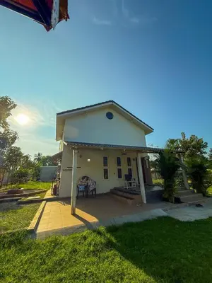 a small white house with a patio in a yard at White House, Managed By Triora Escapes in Maddūr