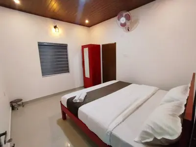 a bedroom with a large bed with a red door at Vythiri Silent Leaf in Wayanad