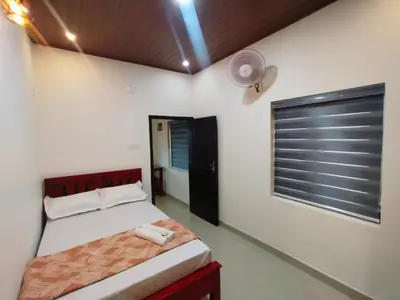 a bedroom with a bed and a window at Vythiri Silent Leaf in Wayanad
