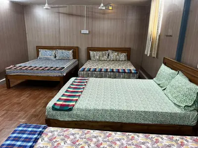 two beds in a room with wooden walls at Raja Residency Near isha Foundation Adiyogi in Coimbatore