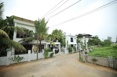 a house with a palm tree in front of it at Ashiyana Homes in Nedumbassery