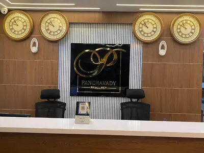a row of clocks on a wall above a counter at PANCHAVADY RESIDENCy in Kodungallūr