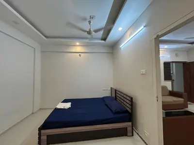 a bedroom with a blue bed and a mirror at Thirteen in Guruvāyūr