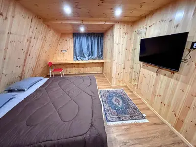 a bedroom with a bed and a flat screen tv at AURA Resort kookal kodaikanal in Kūkkāl