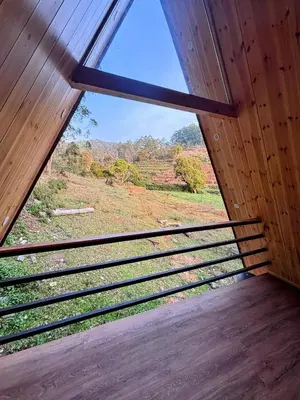 a window in a room with a view of a field at AURA Resort kookal kodaikanal in Kūkkāl