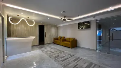 a lobby with a yellow couch in a room at Cloud Nine Hotel - Kuthuparamba in Kuthuparamba