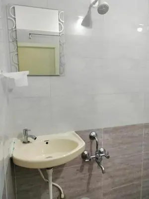 a bathroom with a sink and a mirror at ISIRI Rooms in Mysore