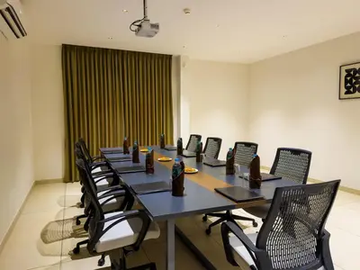 a conference room with a long table and chairs at Hotel Grand Residency in Mannārakkāt