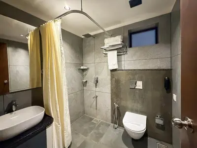 a bathroom with a shower and a toilet and a sink at Hotel Grand Residency in Mannārakkāt