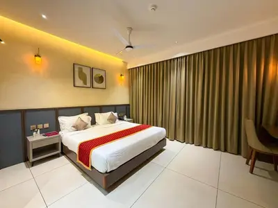 a bedroom with a bed and a large window at Hotel Grand Residency in Mannārakkāt