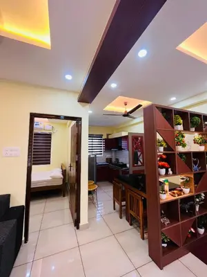 a living room and dining room with a kitchen and a dining table at Panakkal Tower in Guruvāyūr