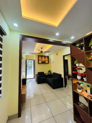 a living room with a black couch in a room at Panakkal Tower in Guruvāyūr
