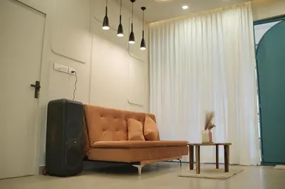 a living room with a brown couch and a tv at The Soul by VDN A Santorini inspired Villa in Trichūr