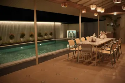 a dining table and chairs next to a swimming pool at The Soul by VDN A Santorini inspired Villa in Trichūr