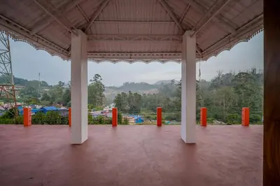 a pavilion with white columns and orange pillars at The Blue Hist in Naduvattam
