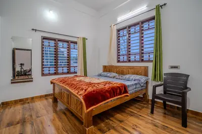 a bedroom with a bed and a chair in it at The Blue Hist in Naduvattam