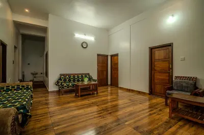 a living room with two couches and a table at The Blue Hist in Naduvattam