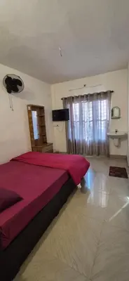 a bedroom with a large bed with a red blanket at Mocha Valley Homestay in Kalpetta