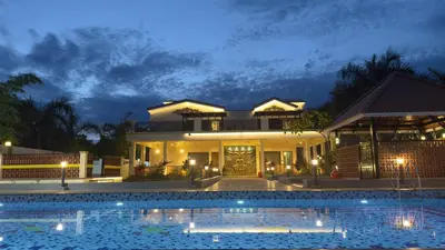 a house with a swimming pool at night at Kurunchi malar Resorts in Hosūr