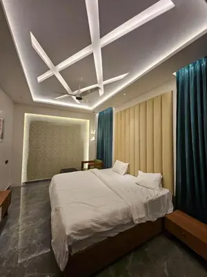 a bedroom with a large bed and a ceiling at Kurunchi malar Resorts in Hosūr