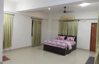a bedroom with a bed and green curtains at Harmony INN Rooms in Palakkad