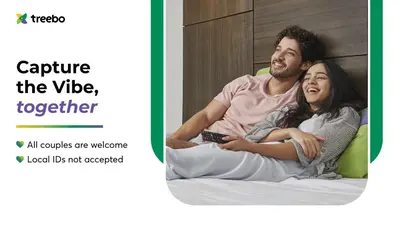 a man and a woman sitting on a bed at Treebo Premium Cachet Suites in Coimbatore