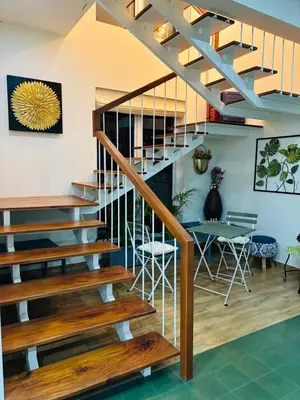 a staircase in a living room with a table and chairs at Traditional house near Cochin airport in Chewarra