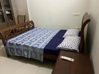 a bed in a room with a remote control on it at Traditional house near Cochin airport in Chewarra