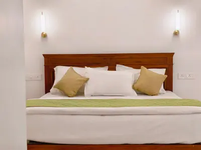 a bedroom with a large bed with white sheets and pillows at Ambadis private pool villa in Pallipuram