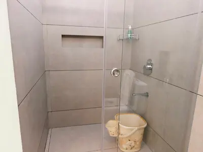 a bathroom with a glass shower with a toilet at Ambadis private pool villa in Pallipuram