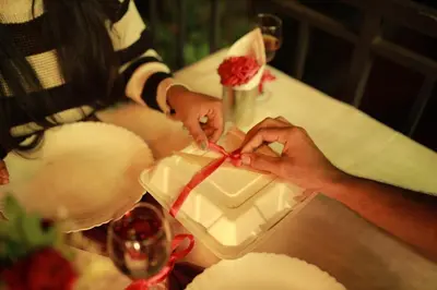 a person tying a red ribbon around a box at Mountain View A frame Pool Villa in Meppādi