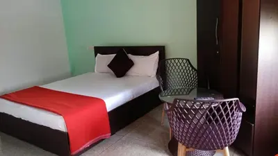 a small bedroom with a bed and a chair at Tamar padinjarathara in Padinjarathara