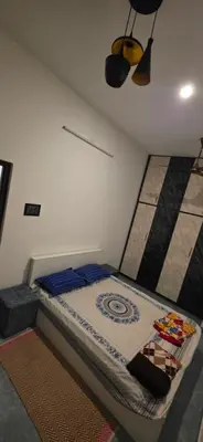 a bedroom with a bed with blue pillows at SARA'S LUXURY stay in Coimbatore (Peelamedu)