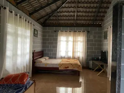 a small bedroom with a bed and a window at Cozy Tiny Farm Stay in Mysore