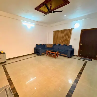 a living room with a couch and a tv at Unnati Luxury Homestay Coorg in Madikeri