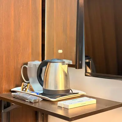 a tea kettle on a table in a hotel room at Unnati Luxury Homestay Coorg in Madikeri