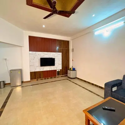 a living room with a tv and a couch and a table at Unnati Luxury Homestay Coorg in Madikeri