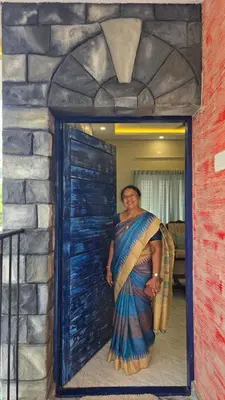 a woman in a blue dress standing in a doorway at Grace villa in Kunnamkulam