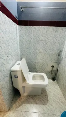a bathroom with a white toilet in a room at Grace villa in Kunnamkulam