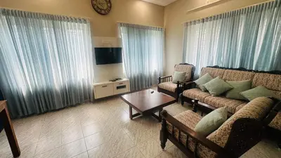 a living room with a couch and a table at Grace villa in Kunnamkulam