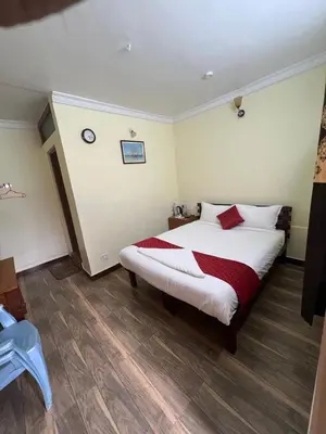 a bedroom with a bed with a red and white blanket at Bull Bull Homestay in Ooty