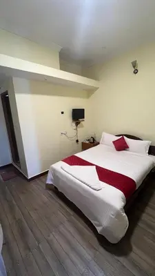 a bedroom with a large white bed with red pillows at Bull Bull Homestay in Ooty