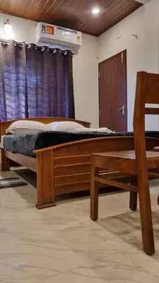 a bedroom with a wooden bed and a window at Hotel Arena in Mahe