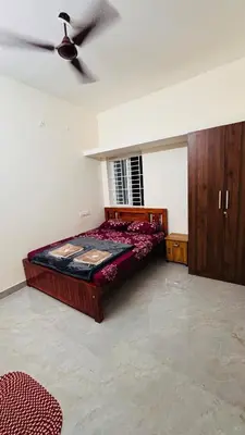 a bedroom with a bed and a ceiling fan at Ashley Homestay 2BHK Codissia, Airport, Tidel Park in Coimbatore