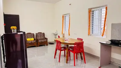 a kitchen with a table and chairs in a room at Ashley Homestay 2BHK Codissia, Airport, Tidel Park in Coimbatore