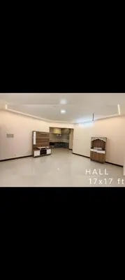 an empty living room with a tv and two chairs at R N P Guest House in Pollāchi