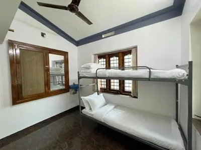 two bunk beds in a room with a ceiling fan at Sreekrishnapuram Family Retreat in Karimpuzha